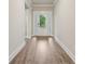 Bright and spacious hallway featuring elegant wood-look floors, leading to the front door at 6340 Arlington Cir, Cumming, GA 30041