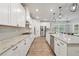 Modern kitchen featuring white cabinets, granite countertops, stainless steel appliances, and stylish pendant lighting at 6340 Arlington Cir, Cumming, GA 30041