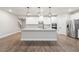 Open-concept kitchen with a large island, stainless steel appliances, and pendant lighting at 6340 Arlington Cir, Cumming, GA 30041