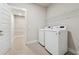 Well-lit laundry room with washer, dryer, and ample shelving at 6340 Arlington Cir, Cumming, GA 30041