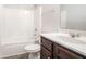 Bathroom with dark wood vanity and a shower-tub combo at 739 Rolling Downs Dr, Loganville, GA 30052