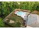 Aerial view of a private fenced backyard with pool, lounge chairs, and wooded surroundings at 632 Creekside Trce, Covington, GA 30014