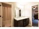 Bathroom with double sinks, dark wood cabinets, granite counters, tub with shower at 632 Creekside Trce, Covington, GA 30014