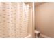 Cozy bathroom with a shower featuring a stylish striped curtain and a standard toilet at 632 Creekside Trce, Covington, GA 30014