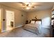 Comfortable bedroom featuring a ceiling fan, carpeting, and view into an attached bathroom at 632 Creekside Trce, Covington, GA 30014