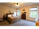 Bright bedroom with two windows, ceiling fan, and carpeted floor, offering a comfortable living space at 632 Creekside Trce, Covington, GA 30014