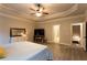 Large bedroom with ceiling fan, recessed ceiling, and view to Primary bathroom at 632 Creekside Trce, Covington, GA 30014