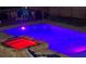 Inviting in-ground pool and hot tub with stone surround and colorful lighting for evening enjoyment at 632 Creekside Trce, Covington, GA 30014