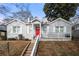 Charming bungalow-style home with a red front door, stone steps, and a well-maintained lawn at 1320 Hosea L Williams Ne Dr, Atlanta, GA 30317