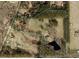 An aerial view of a large property with a pond and partially wooded landscape at 576 Tope Rd, Sharpsburg, GA 30277