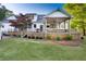 The spacious backyard features a covered deck and patio, a manicured lawn and mature trees at 576 Tope Rd, Sharpsburg, GA 30277