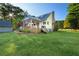 A lovely backyard view of a home with a large green lawn, covered porch and storage building at 576 Tope Rd, Sharpsburg, GA 30277