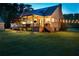 Relaxing backyard includes a covered deck, string lights, a fire pit, and lush green space at 576 Tope Rd, Sharpsburg, GA 30277