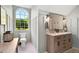 Bathroom featuring double sinks, wood cabinetry and wainscoting, and a beautiful window at 576 Tope Rd, Sharpsburg, GA 30277