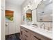 Bright bathroom featuring a double vanity, decorative mirrors, and a shower with tiled walls at 576 Tope Rd, Sharpsburg, GA 30277