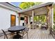 Covered outdoor wooden deck with ceiling fan, tv and outdoor dining and seating at 576 Tope Rd, Sharpsburg, GA 30277