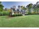 A charming two-story home with a well-manicured lawn, mature trees and a covered front porch at 576 Tope Rd, Sharpsburg, GA 30277