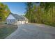 View of detached garage with a three-car capacity, long driveway, basketball hoop and beautiful trees in the background at 576 Tope Rd, Sharpsburg, GA 30277