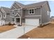 Beautiful two-story gray house with white trim, a large driveway, and a well-maintained lawn at 131 Hampton Ter, Dallas, GA 30157