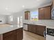 Open kitchen with stainless steel appliances, granite countertops, wood cabinets, and light wood-look flooring at 171 Hampton Ter, Dallas, GA 30157