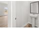 Modern powder room with a pedestal sink, framed mirror and wood look flooring at 171 Hampton Ter, Dallas, GA 30157