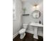 Charming half bathroom with pedestal sink, round mirror, and hardwood floors at 2136 Oak Knob Dr, Decatur, GA 30032