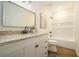 Bright bathroom featuring a modern vanity with granite countertops and a bathtub with tile surround at 2294 Salt Springs Pl, Austell, GA 30168