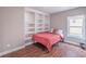 Bedroom features a large built in bookshelf, wood floors and a window providing natural light at 2675 Sugar Mill Dr, Atlanta, GA 30316