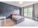 Spacious bedroom featuring a gray bed, a desk area, and natural light from large windows with a dark blue accent wall at 2675 Sugar Mill Dr, Atlanta, GA 30316