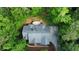 Aerial view of the home showcasing the roof, driveway, wooden deck, and lush surrounding greenery at 415 Morgan Falls Chase, Canton, GA 30114