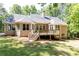 Back exterior view of the home showcasing a wooden deck, beautiful windows, and well-maintained lawn at 415 Morgan Falls Chase, Canton, GA 30114