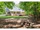 Spacious backyard with a stone fire pit, wooden deck, and lush green lawn surrounded by mature trees at 415 Morgan Falls Chase, Canton, GA 30114
