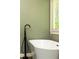 Close-up of luxurious white soaking tub with black modern faucet and natural light at 415 Morgan Falls Chase, Canton, GA 30114