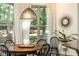 Charming breakfast nook features a round wooden table with black chairs, sunburst mirror, and natural light at 415 Morgan Falls Chase, Canton, GA 30114