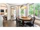 Sunny breakfast nook with a round table, black chairs, hardwood floors, and large windows overlooking a lush yard at 415 Morgan Falls Chase, Canton, GA 30114