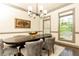 Elegant dining room features a dark wood table, six chairs, a modern chandelier, and natural light at 415 Morgan Falls Chase, Canton, GA 30114