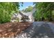 Beautiful two-story home with a long driveway, nestled among lush trees on a sunny day at 415 Morgan Falls Chase, Canton, GA 30114