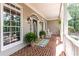 Spacious front porch with brick flooring, rocking chairs, and a charming entrance at 415 Morgan Falls Chase, Canton, GA 30114