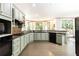 The kitchen features light green cabinets, modern appliances, granite countertops, hardwood floors, and a breakfast nook at 415 Morgan Falls Chase, Canton, GA 30114