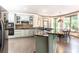 The spacious open kitchen features light green cabinets, stainless appliances, granite countertops, and wood flooring at 415 Morgan Falls Chase, Canton, GA 30114