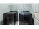 This laundry room features sleek, modern, black front-loading washer and dryer, and a wire rack for storage at 415 Morgan Falls Chase, Canton, GA 30114