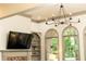 A stylish living room features a brick fireplace, built-in shelving, arched windows, and modern lighting fixtures at 415 Morgan Falls Chase, Canton, GA 30114