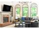 Cozy living room with fireplace, custom built-ins, and arched windows providing ample natural light and scenic views at 415 Morgan Falls Chase, Canton, GA 30114