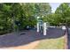 Community playground set in a wooded area with mature trees and a privacy fence at 415 Morgan Falls Chase, Canton, GA 30114