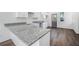 Bright kitchen showcasing granite countertops, white cabinetry, and wood flooring at 100 Dahlia Nw Ave, Atlanta, GA 30314