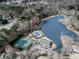 An aerial view showcases community amenities, including a pool, tennis courts, clubhouse, and a picturesque lake at 1594 Stoddard Nw Ct, Kennesaw, GA 30152