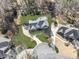 An aerial view of a residence with a well-manicured lawn, framed by mature trees and a winding driveway at 1594 Stoddard Nw Ct, Kennesaw, GA 30152