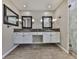 Elegant bathroom featuring double vanity with granite countertop, framed mirrors, and a glass-enclosed shower at 1594 Stoddard Nw Ct, Kennesaw, GA 30152