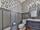 Cozy powder room boasts stylish wallpaper and modern fixtures at 1594 Stoddard Nw Ct, Kennesaw, GA 30152