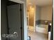 Open bathroom featuring a glass shower, soaking tub, and neutral-toned tile flooring at 3604 Sw Wartrace Sw Dr, Atlanta, GA 30331